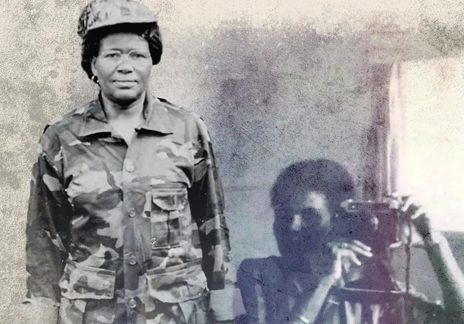 Black and white photo shows two African women, one in military camouflage, the other with what might be a firearm or camera